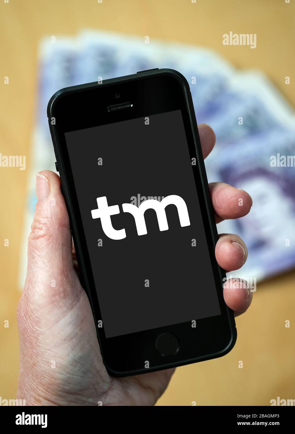 Una donna che guarda il logo Think Money Bank su un telefono cellulare. (Solo per uso editoriale) Foto Stock