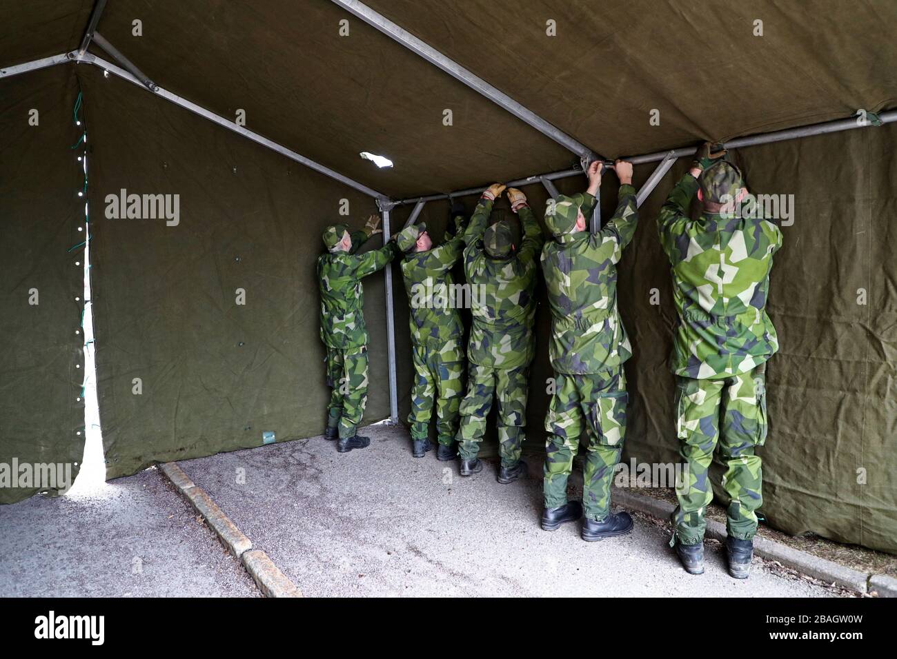 Motala, Svezia 20200315 la Guardia di Casa (la Guardia di Casa - forze di sicurezza nazionali è una forza militare di riserva delle forze armate svedesi) assiste la sanità e la Regione Östergötland con tende per ordinare i pazienti in connessione con il coronavirus, covid-19. Qui si allestì una tenda all'ospedale di Motala. Foto Jeppe Gustafsson Foto Stock