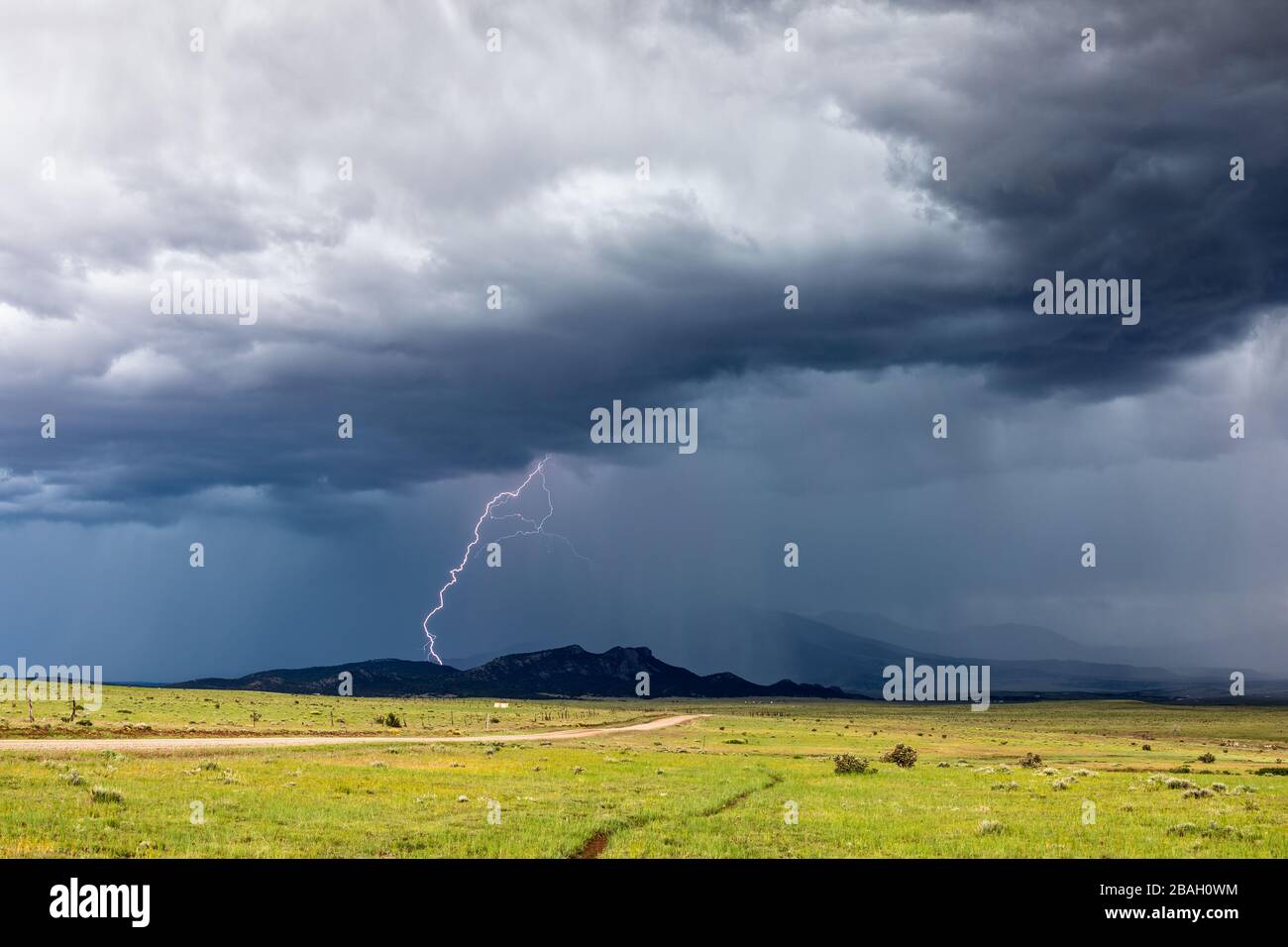 Un fulmine da nuvola a terra colpisce una cresta come un forte temporale costruito ai piedi delle Montagne Rocciose nei pressi di Walsenburg, Colorado Foto Stock