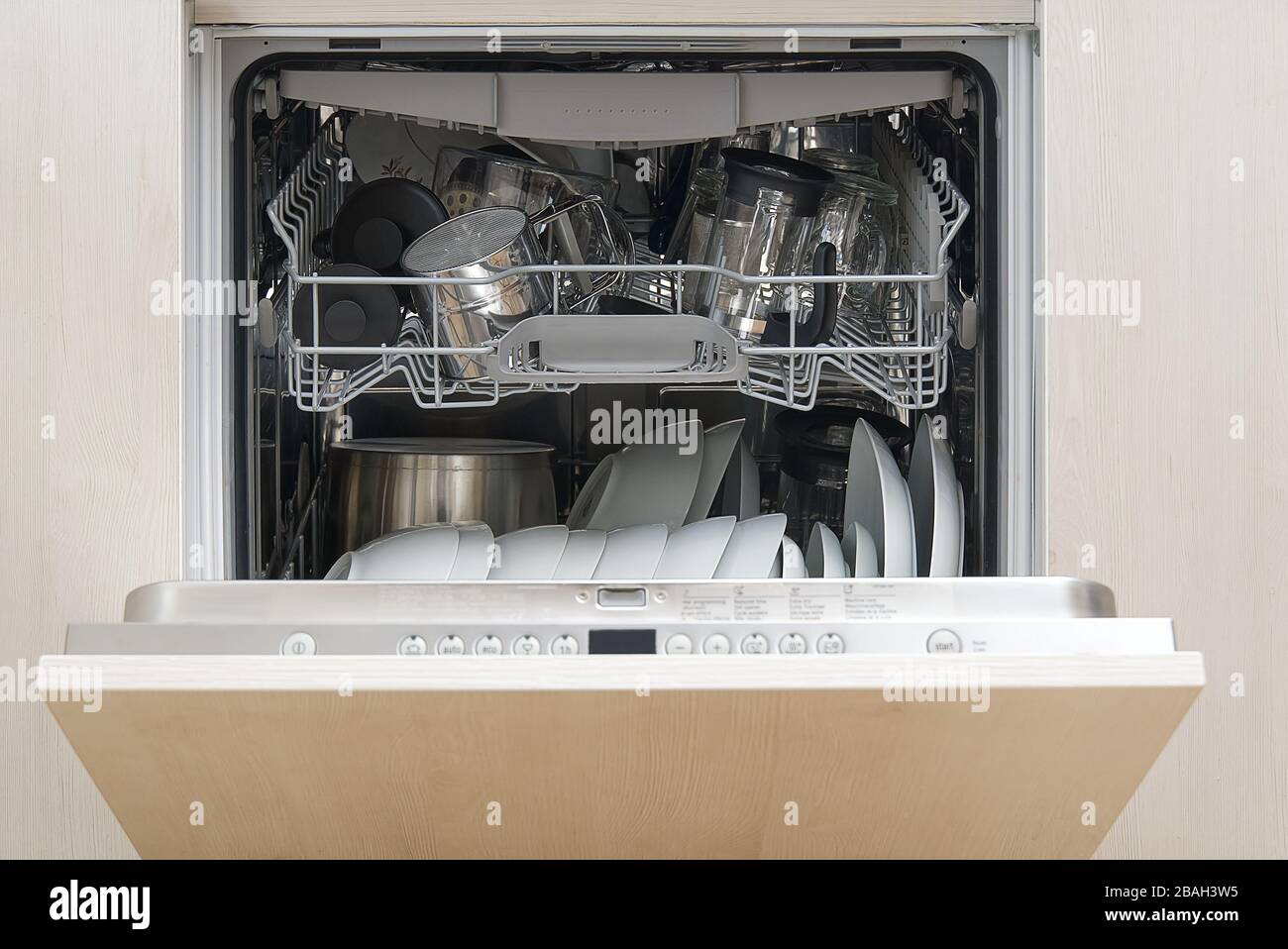 Lavastoviglie a pieno carico. Lavastoviglie integrata con piastra bianca frontale. Foto Stock