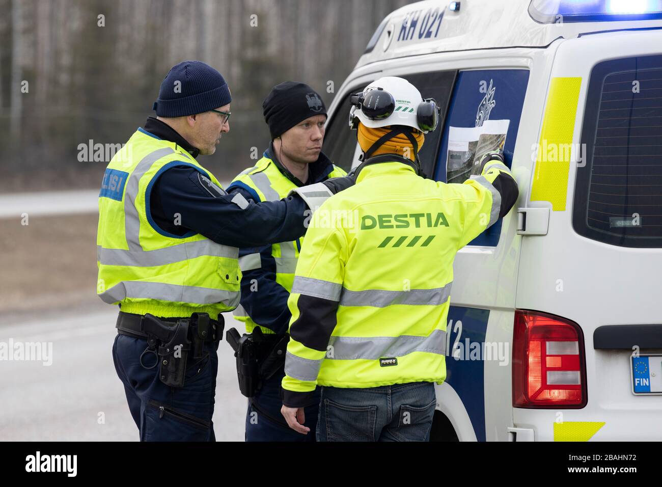 Helsinki, regione di Uusimaa in Finlandia. 27 marzo 2020. Gli agenti di polizia e un lavoratore della strada si preparano per il blocco su una strada a Hyvinkaa, sul bordo settentrionale della regione di Uusimaa in Finlandia, 27 marzo 2020. Per evitare l'ulteriore diffusione del coronavirus, mercoledì il governo finlandese ha lanciato un piano per bloccare la regione Uusimaa più colpita del paese, che comprende la capitale Helsinki. Ci si aspettava che il blocco iniziasse il venerdì sera sotto la supervisione della polizia. Credit: Matti Matikainen/Xinhua/Alamy Live News Foto Stock