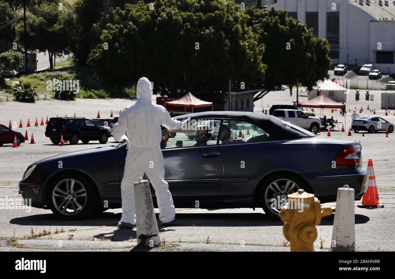 Los Angeles, Stati Uniti. 27 marzo 2020. Un operatore sanitario in tuta protettiva lavora presso un sito di test drive-thru per coronavirus nel Parco Elysian di Los Angeles, Stati Uniti, 27 marzo 2020. Credit: Xinhua/Alamy Live News Foto Stock