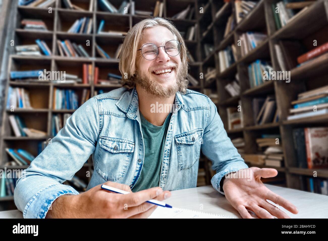Giovane blogger studente bearded guardare la macchina fotografica ridere scherzo. Foto Stock