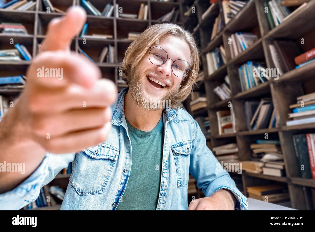 Giovane barbuto studente sorridente blogger guardare punto di macchina fotografica. Foto Stock