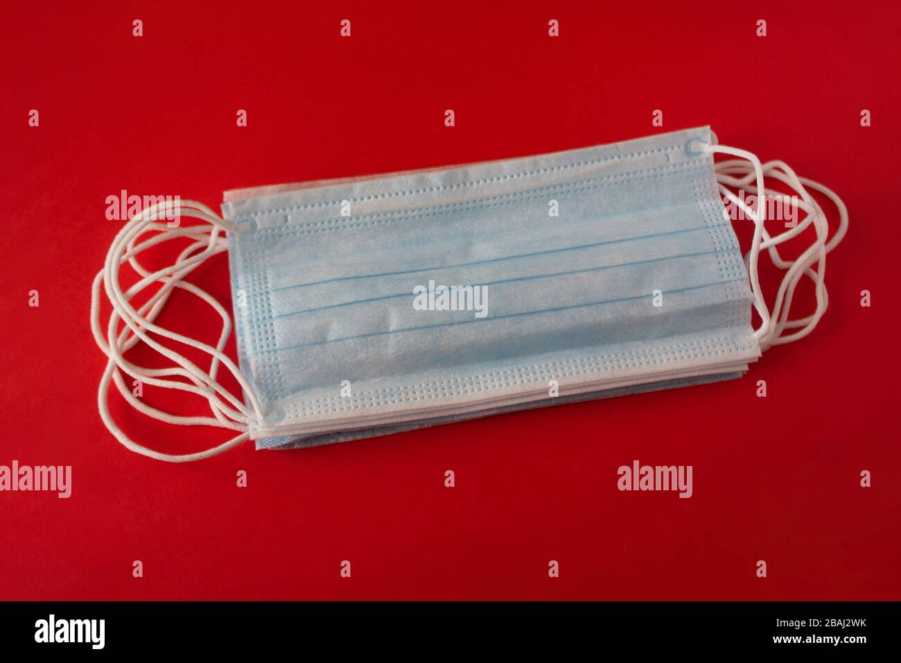 Maschere mediche su sfondo rosso. Pandemia disinvoltura diffusione in tutto il mondo. Trattamento medico delle persone infette. Assistenza sanitaria Foto Stock