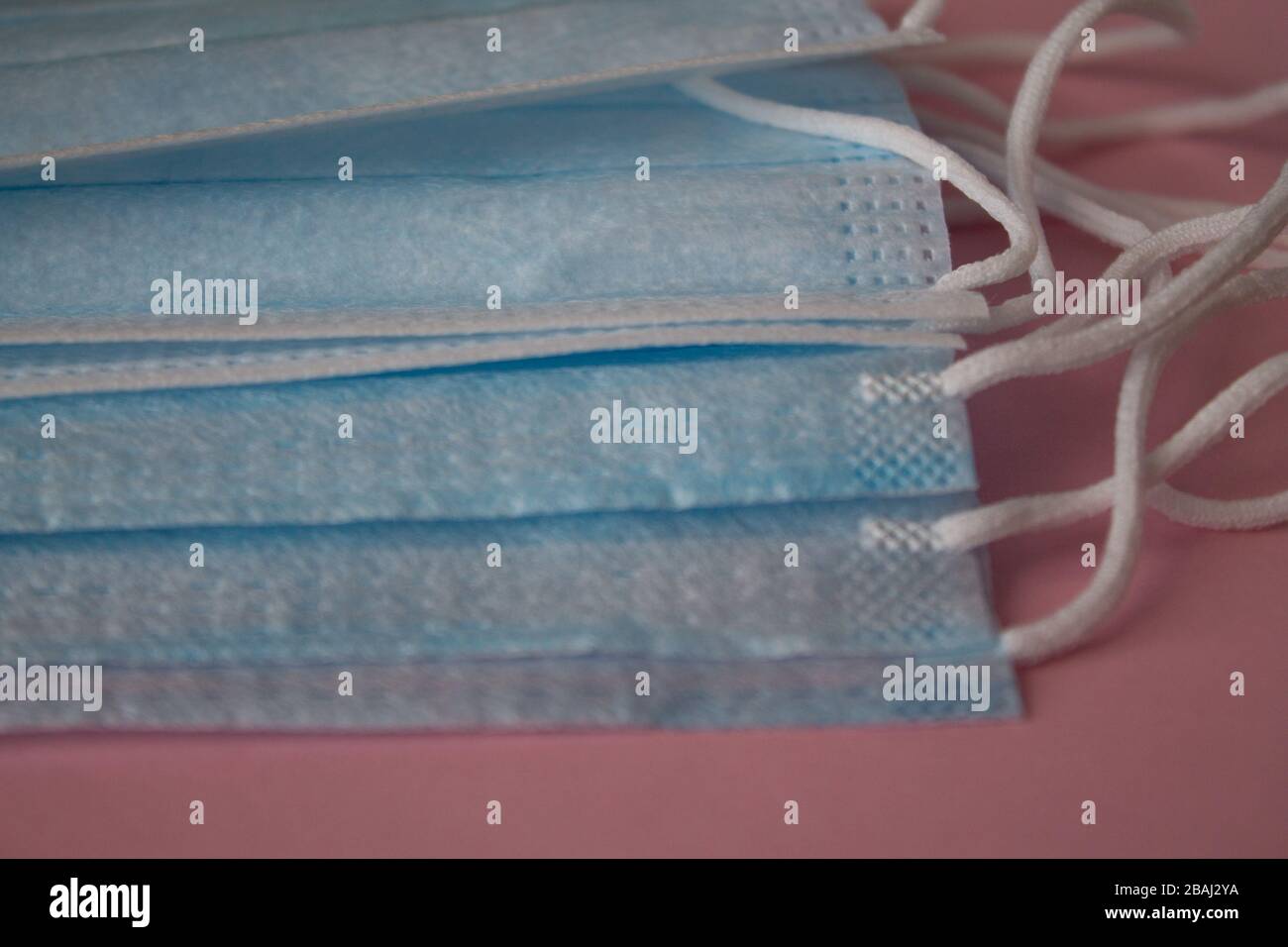 Maschere mediche su sfondo rosa. La disperazione pandemica si diffonde in tutto il mondo. Trattamento medico delle persone infette. Assistenza sanitaria Foto Stock