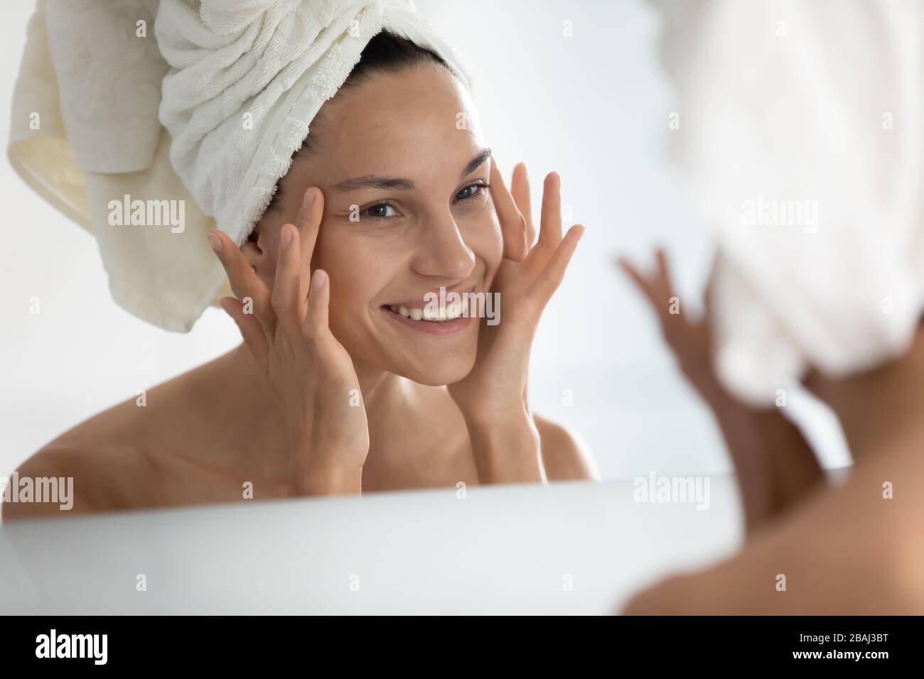 Dopo la procedura domestica di bellezza la donna che guarda la pelle ritiene soddisfatta Foto Stock