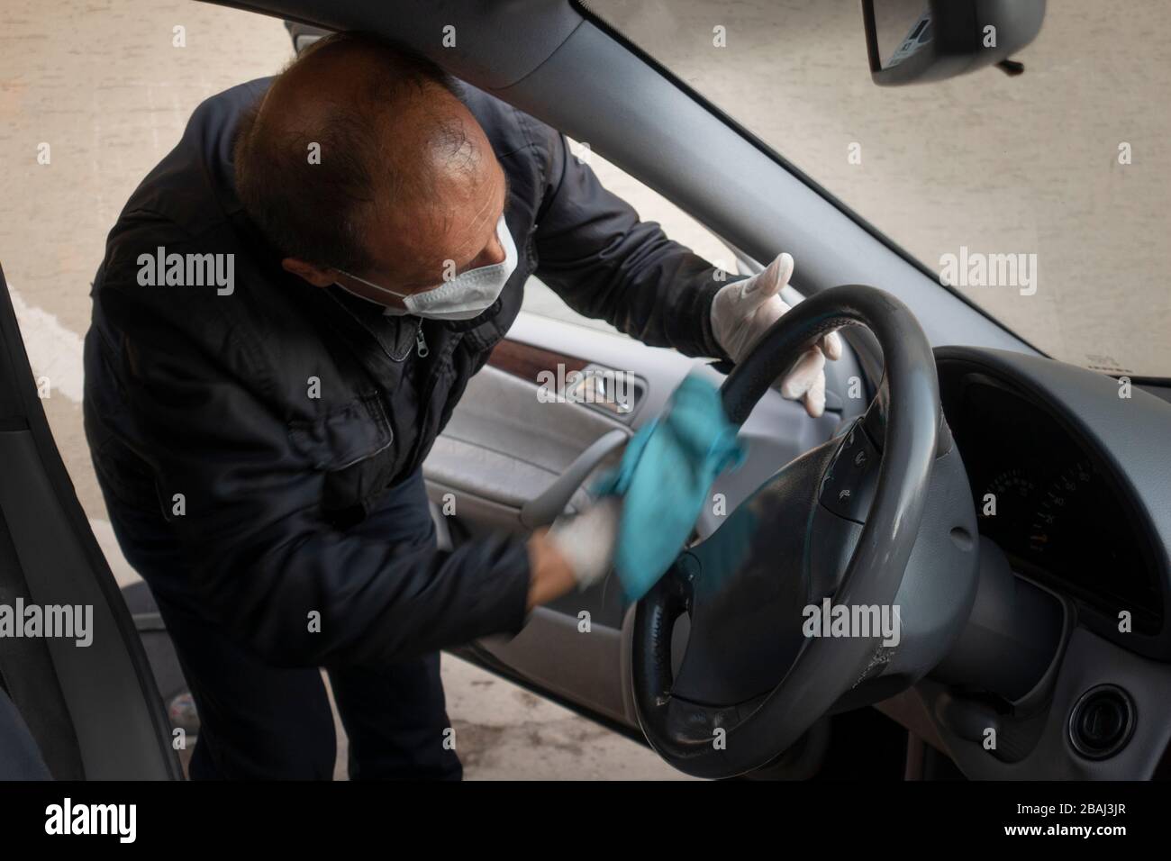 L'uomo turco di mezza età disinfetta la sua auto come precauzione per il virus pandemico della corona Foto Stock