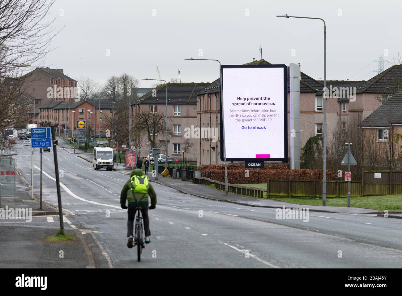 Parkhouse, Glasgow, Scotland, UK durante il 2020 coronavirus lockdown - nhs coronavirus segno di informazioni che domina la strada molto più tranquilla Foto Stock
