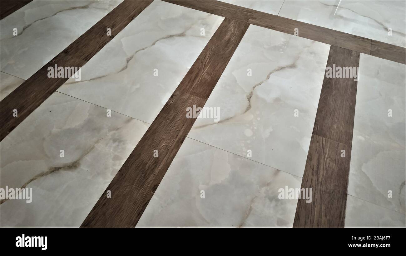 Impressionante motivo del pavimento in marmo bianco brunastro e bordi di finitura in legno di teak marrone marrone chiaro, India Foto Stock