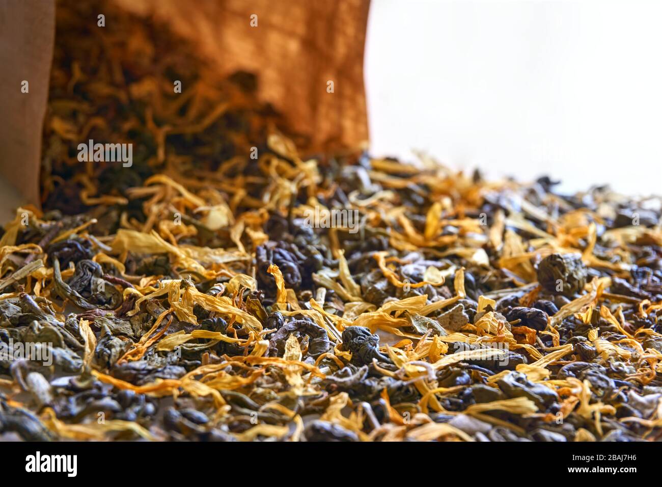 Tisana closeup. Foglie di tè alle erbe multicolori e sacchetto di carta kraft marrone con messa a fuoco selettiva. Foto Stock