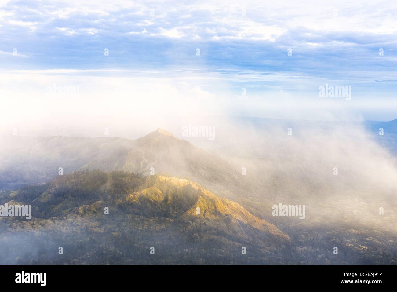 Splendida vista aerea di una splendida catena montuosa circondata da nuvole durante l'alba. Complesso Vulcano Ijen. Vulcano Ijen, Giava Orientale, Indonesia. Foto Stock