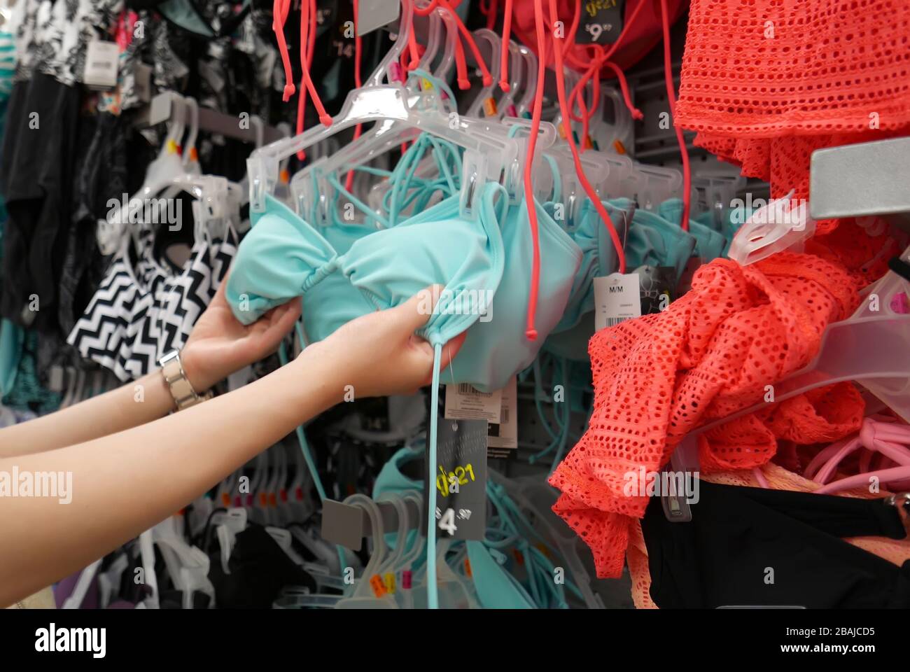 Donna che acquista costume da bagno all'interno del negozio Walmart Foto Stock