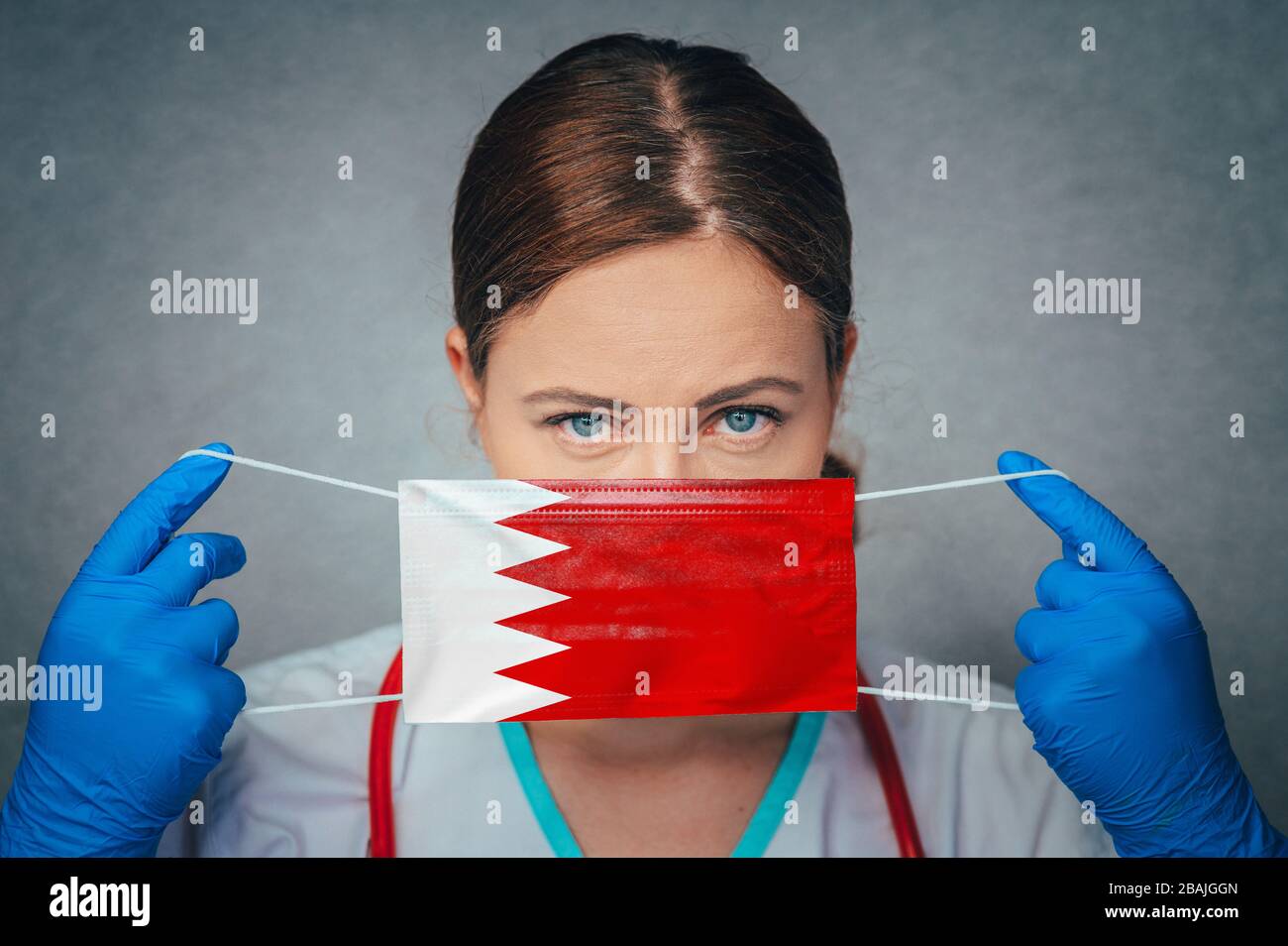 Coronavirus in Bahrain femmina Dottore Ritratto Hold proteggere viso maschera medica chirurgica con Bahrain National Flag. Malattia, virus Covid-19 in Bahrein, Foto Stock