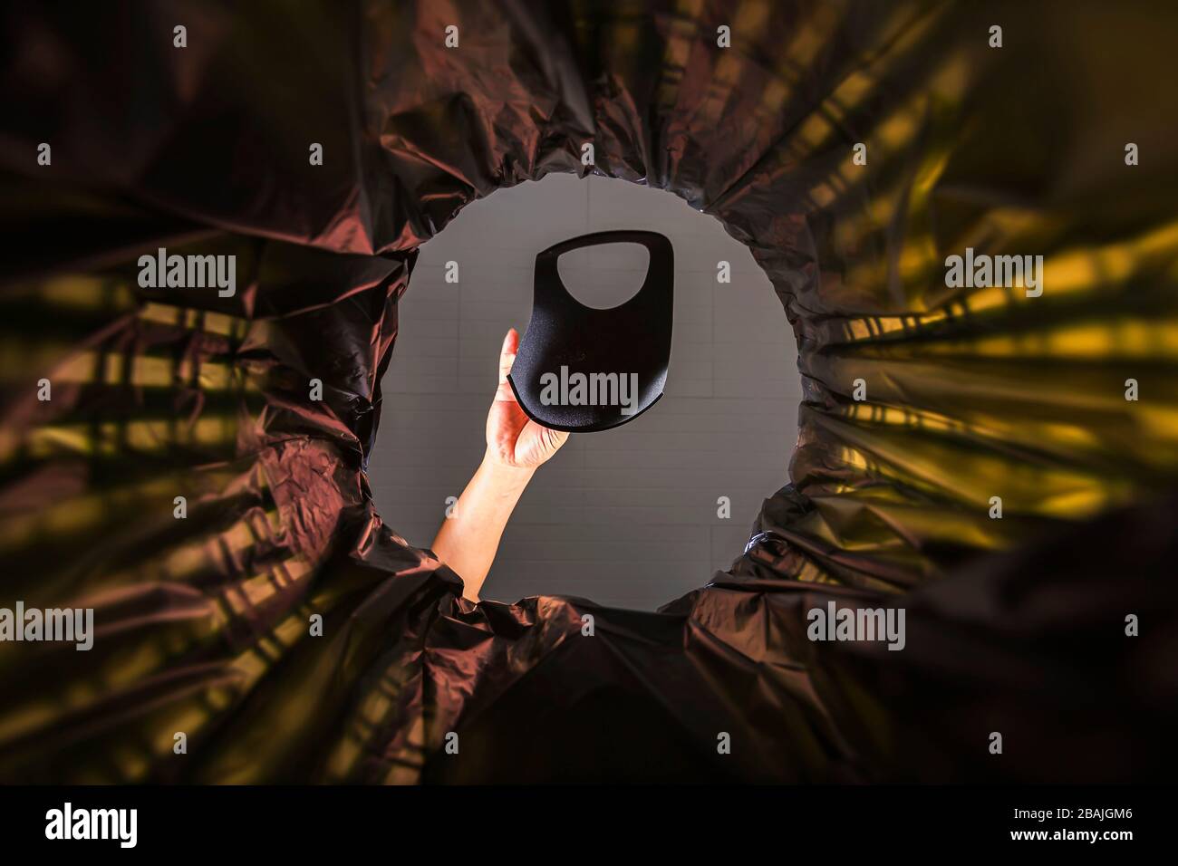 Gettare una maschera facciale nel cestino. Con una vista a vite senza fine dall'interno del cestino. Foto Stock