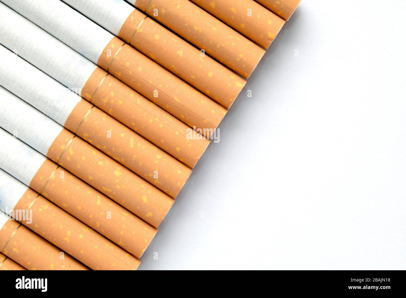 Sigarette in una riga su uno sfondo bianco isolato con copyspace per messaggi aggiuntivi Foto Stock