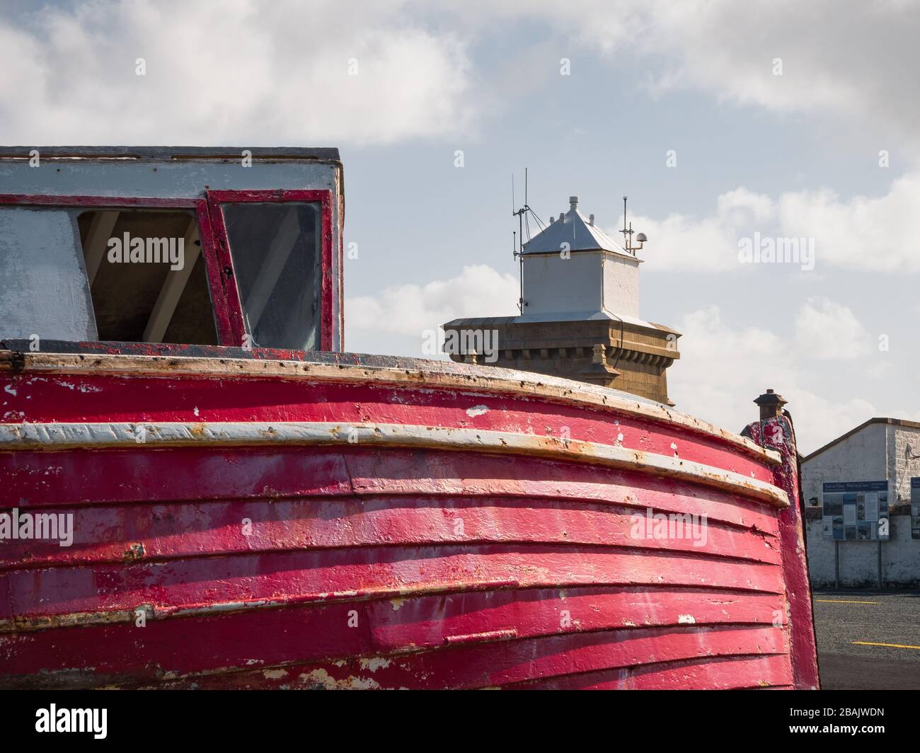 Nave con faro sullo sfondo in Irlanda Foto Stock