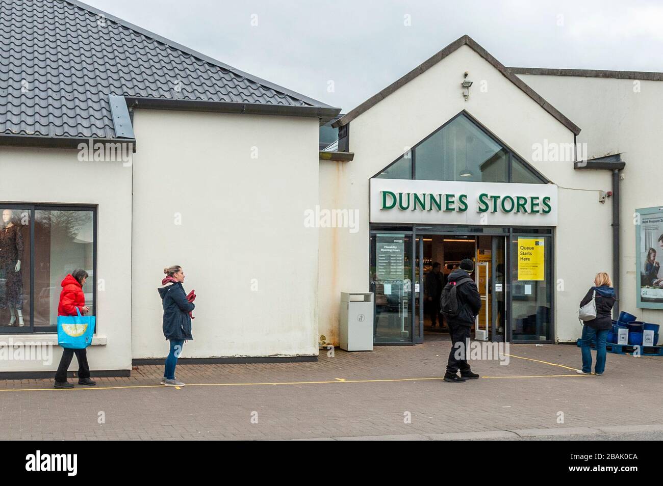 Clonakilty, West Cork, Irlanda. 28 Marzo 2020. Nonostante un Taoiseach, Leo Varadkar, che diceva che la popolazione irlandese dovrebbe rimanere a casa per tutti i viaggi, ma essenziali, a causa di Covid-19, c'era una grande coda fuori dai negozi Dunnes a Clonakilty oggi. La maggior parte degli acquirenti ha atteso 20-30 minuti per entrare nel negozio per il loro negozio settimanale. La direzione di Dunnes Stores ha affermato che solo 75 persone sono state autorizzate a entrare nello shop contemporaneamente e che i clienti si attendevano alle linee guida per le distanze sociali. Credit: Notizie dal vivo di AG/Alamy Foto Stock