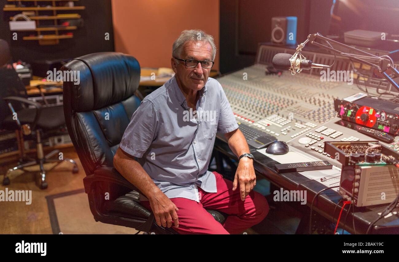 Uomo maturo alla scrivania di missaggio in uno studio di registrazione Foto Stock