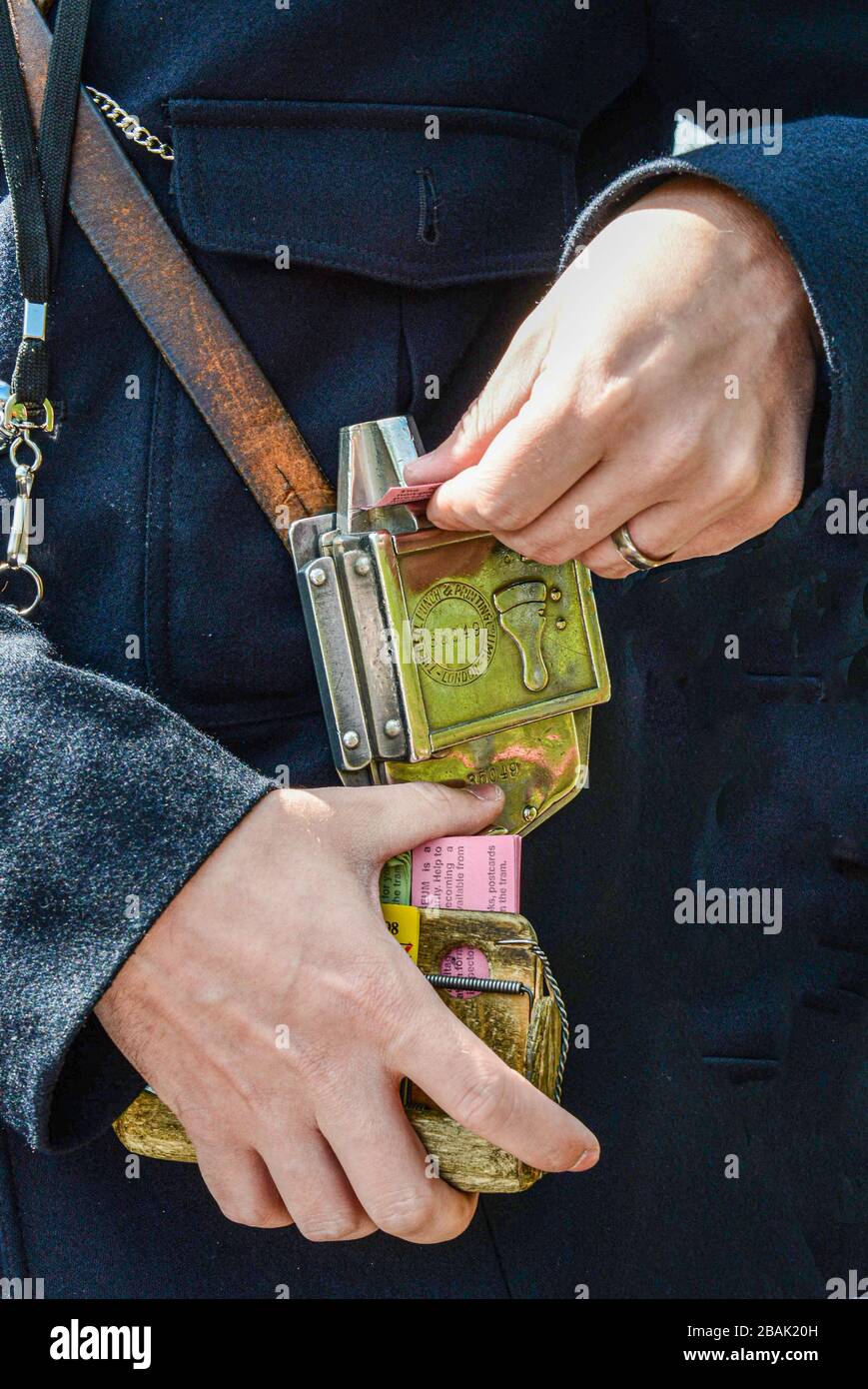Bus/tram conduttore di raccolta tariffe emissione e punzonatura biglietti su vecchia macchina Bell Punch in ottone Foto Stock