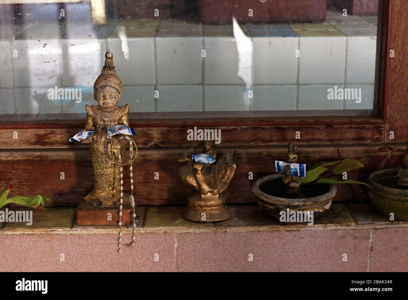 Figurine di dèi con offerte in un tempio buddista, Myanmar Foto Stock