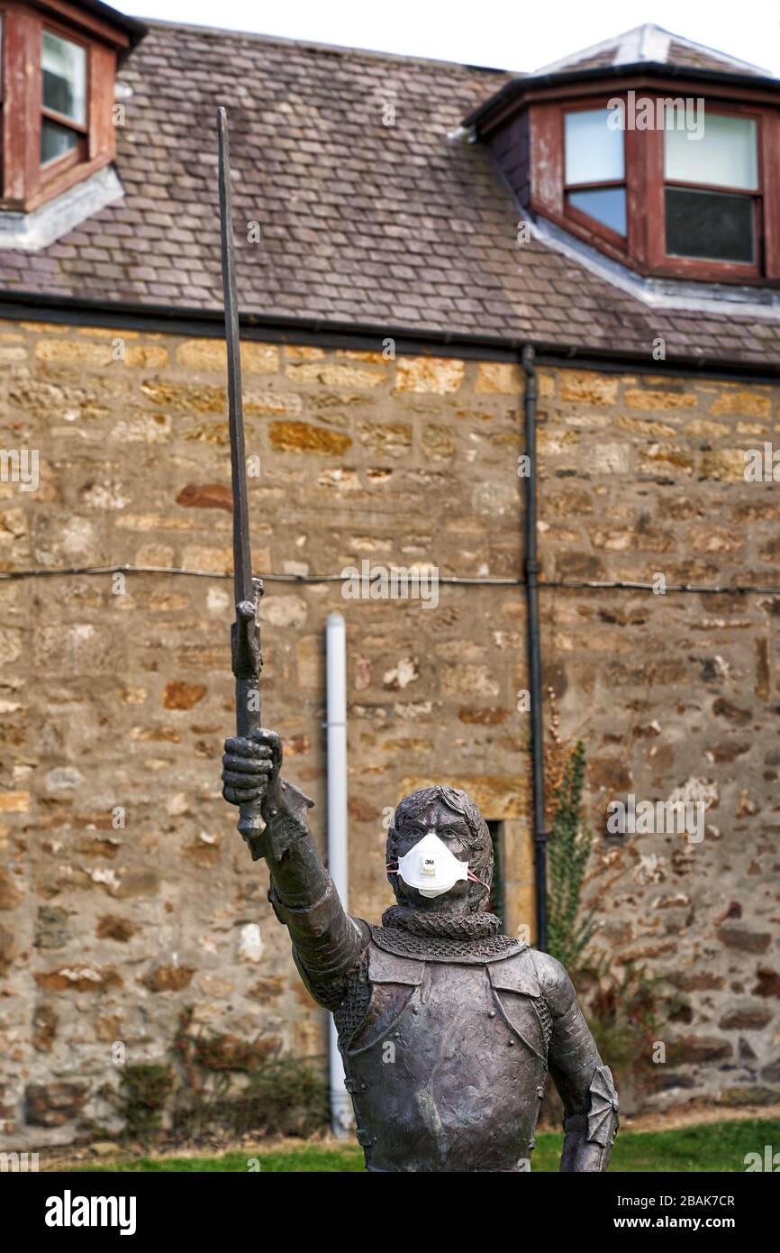 Alexandra Road, Elgin, Moray, Regno Unito. 28 Marzo 2020. REGNO UNITO. Questa è la statua di Alexander Stewart, conte di Buchan, Alasdair Mór mac an Rígh, e chiamato il lupo di Badenoch (1343 - 20 giugno 1405), è stato il terzo figlio sopravvissuto del re Roberto II di Scozia e più giovane dalla sua prima moglie, Elizabeth Mure di Rowallan. Ha adornato la sua maschera per combattere COVID-19. Credit: JASPERIMAGE/Alamy Live News Foto Stock