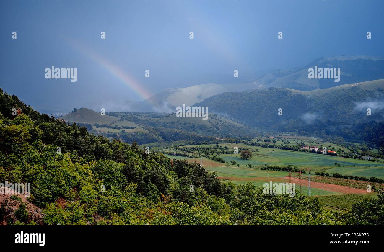 Splendido paesaggio montano con lussureggianti verdi colline ondulate e arcobaleno doppio Foto Stock