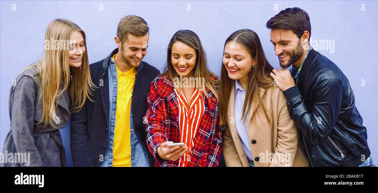 Un gruppo di persone in piedi con i loro smartphone a portata di mano e godere di contenuti online amici utilizzando cellulari e momenti di condivisione - concetto di tecnologia Foto Stock