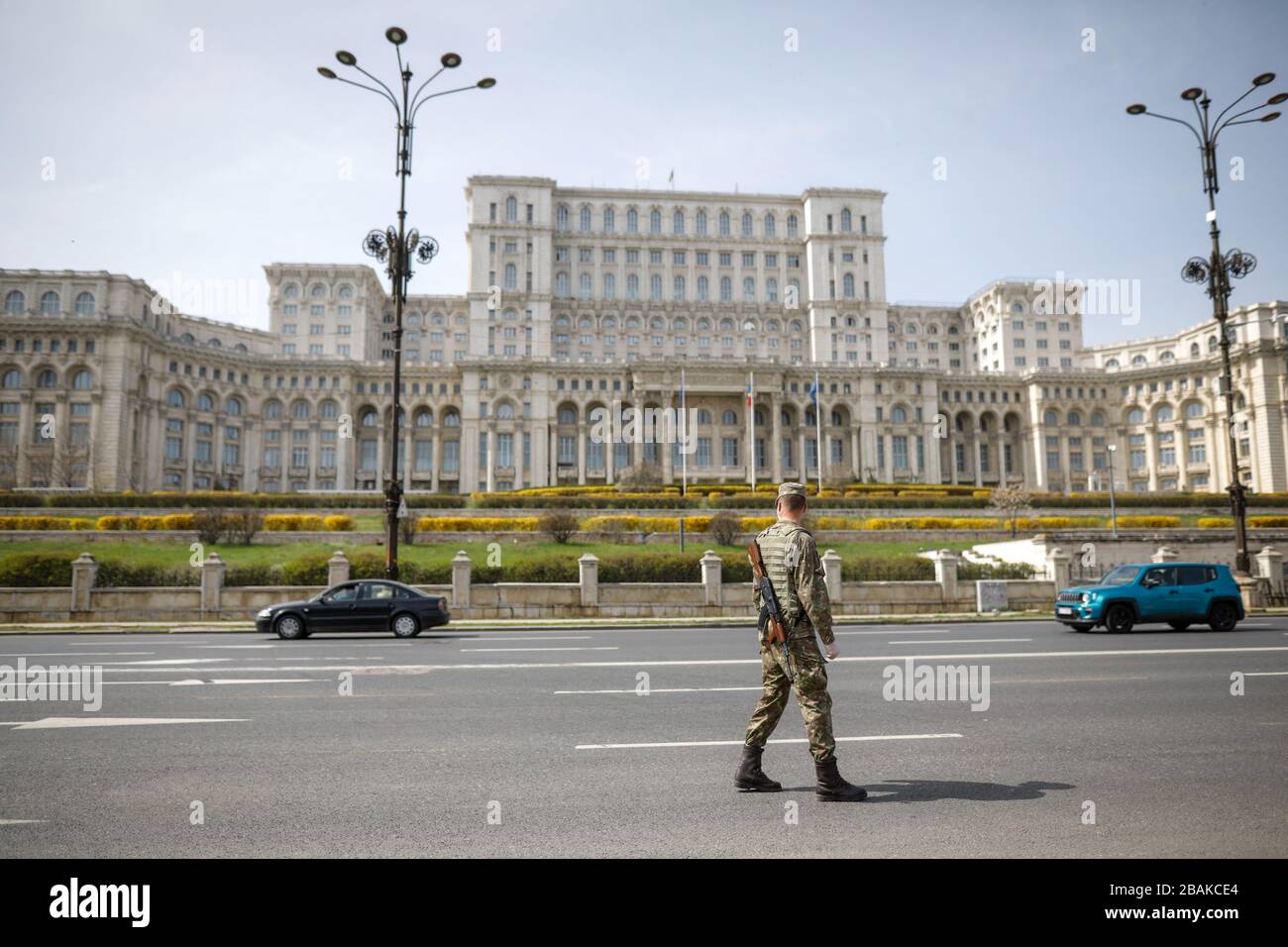 Bucarest, Romania - 28 marzo 2020: Soldato dell'esercito rumeno di fronte al Palazzo del Parlamento per imporre un blocco di un giorno intero per limitare la diffusione di Foto Stock