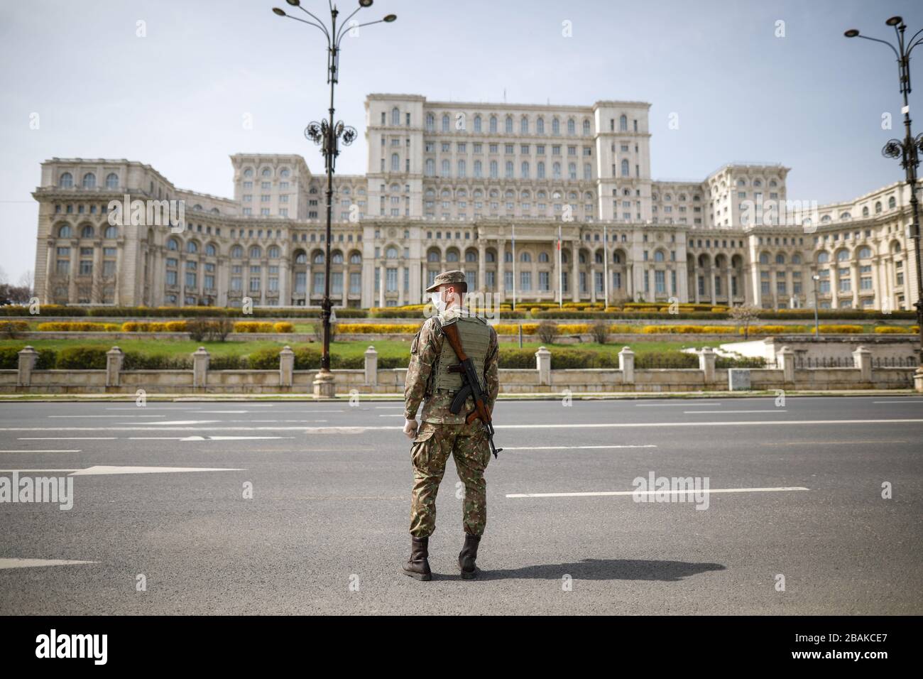 Bucarest, Romania - 28 marzo 2020: Soldato dell'esercito rumeno di fronte al Palazzo del Parlamento per imporre un blocco di un giorno intero per limitare la diffusione di Foto Stock