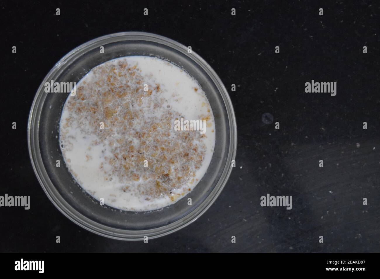 Ciotola di grano mescolato con latte caldo a basso contenuto di grassi e miele Foto Stock