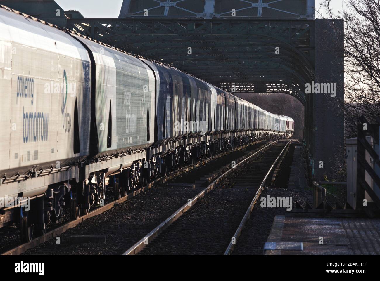 Lungo treno di carri ferroviari Drax Biomass che attraversano il ponte di King George V ad Althorpe Lincolnshire trainato da una locomotiva DBC cargo UK classe 66 Foto Stock