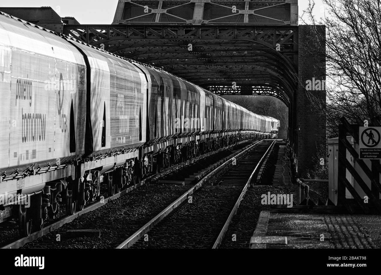 Lungo treno di carri ferroviari Drax Biomass che attraversano il ponte di King George V ad Althorpe Lincolnshire trainato da una locomotiva DBC cargo UK classe 66 Foto Stock