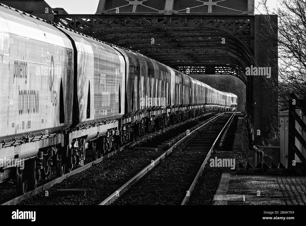 Lungo treno di carri ferroviari Drax Biomass che attraversano il ponte di King George V ad Althorpe Lincolnshire trainato da una locomotiva DBC cargo UK classe 66 Foto Stock