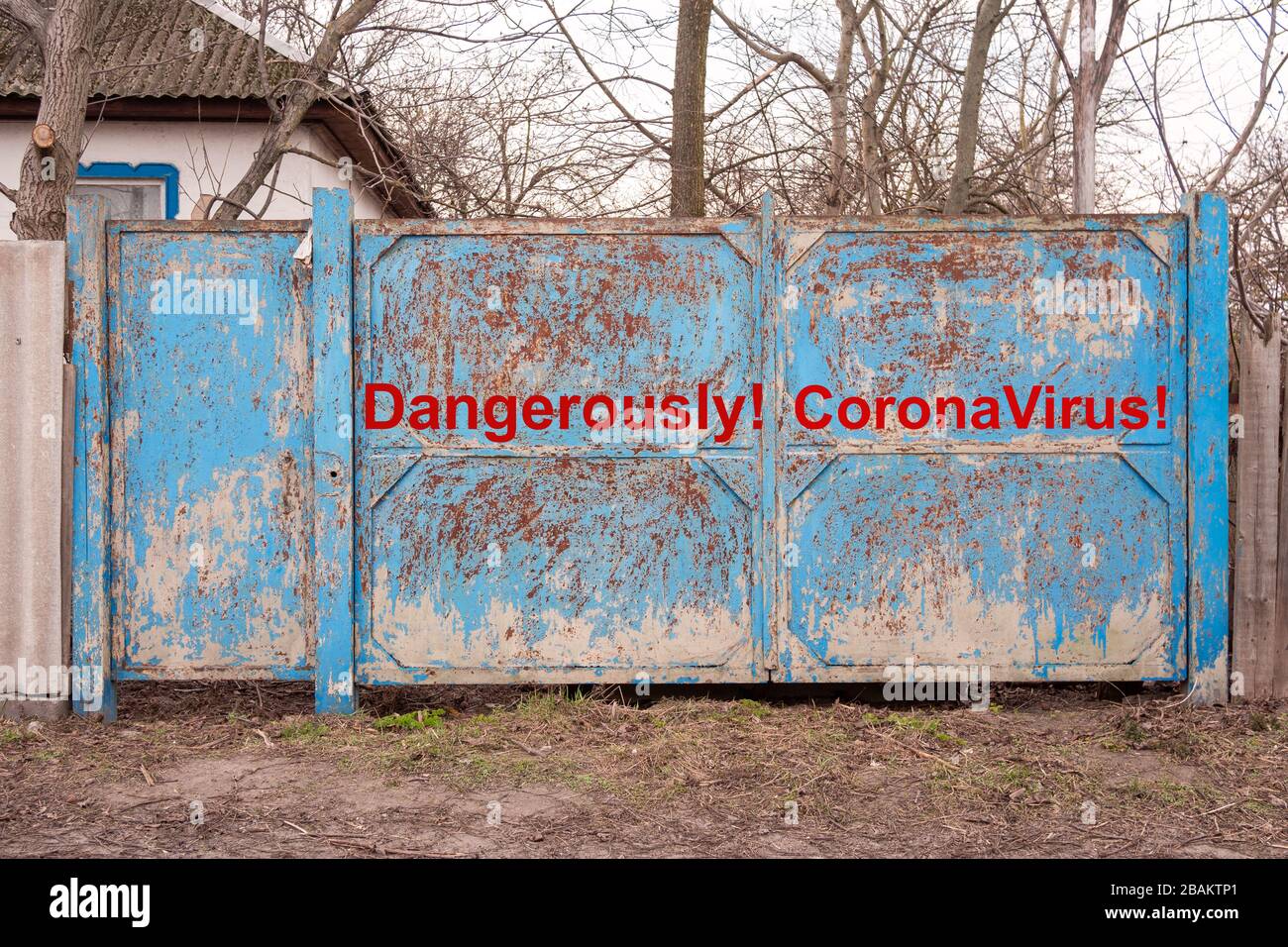 Cancello chiuso nel villaggio. Iscrizione pericolosamente Coronavirus. Quarantena da coronavirus epidemico o covid-19. Misure preventive di protezione contro Foto Stock