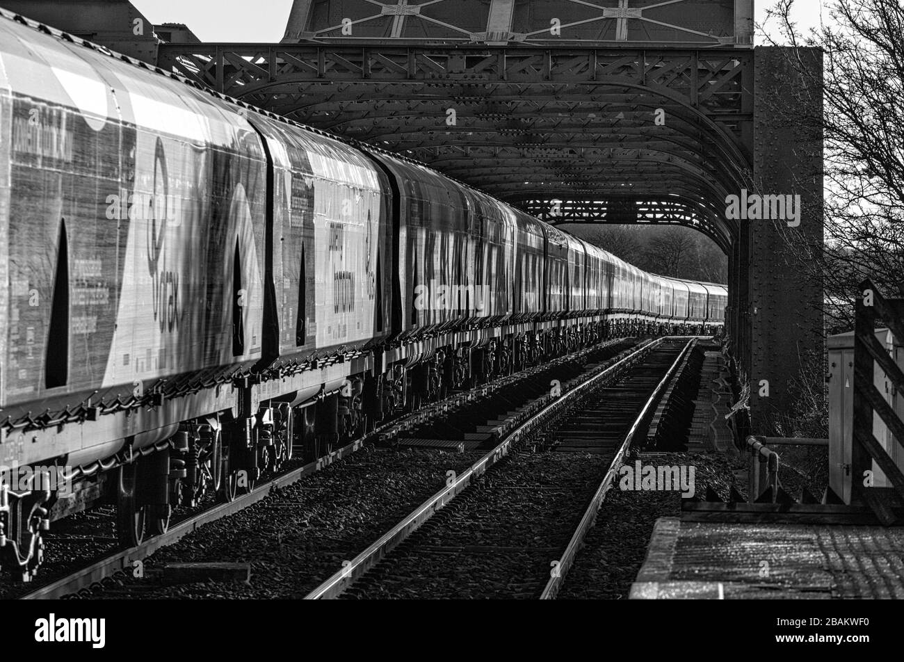 Lungo treno di carri ferroviari Drax Biomass che attraversano il ponte di King George V ad Althorpe, Lincolnshire Foto Stock