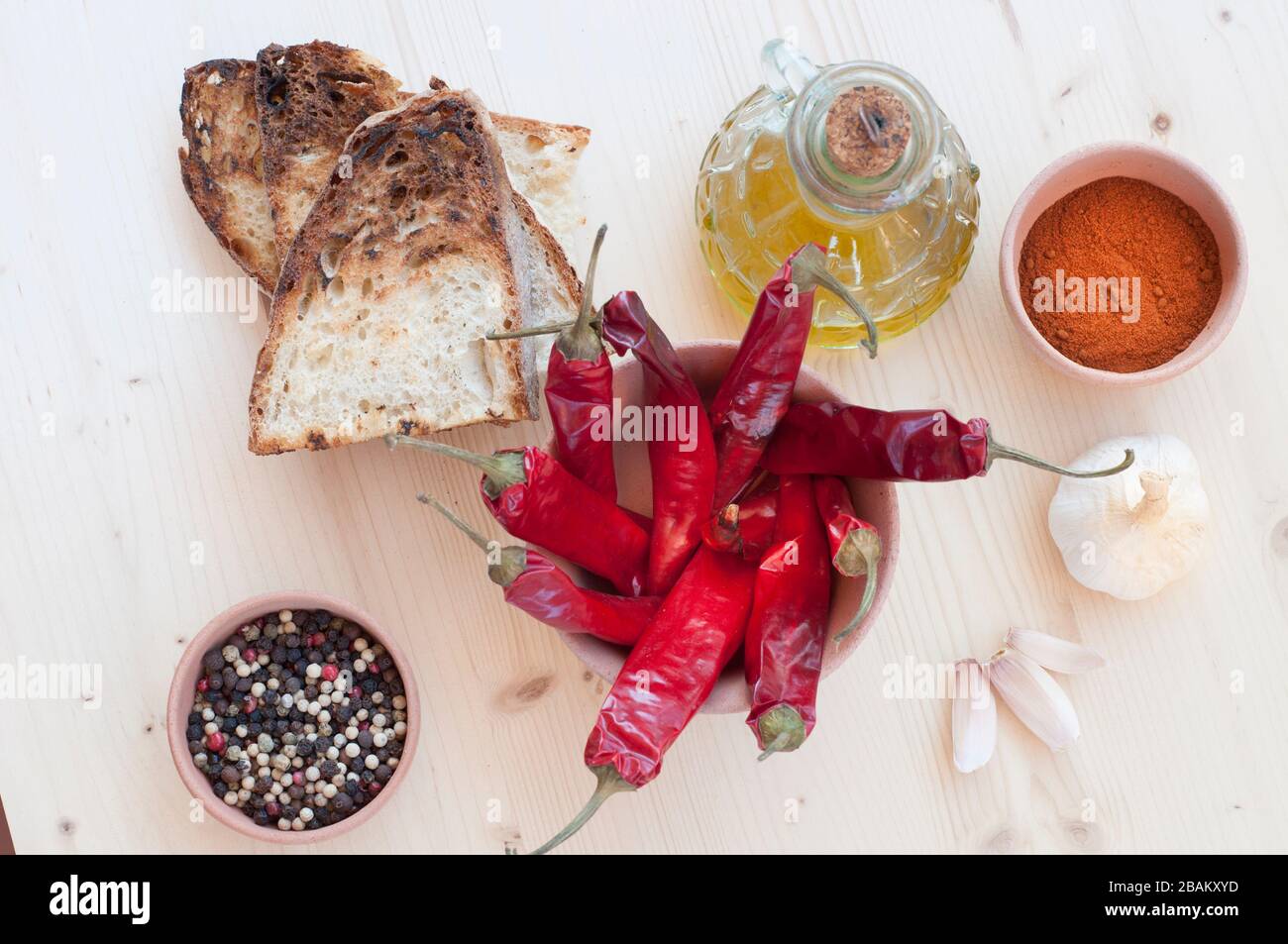 Peperoncino rosso, olio, pane, aglio e pepe in un vaso di argilla Foto Stock