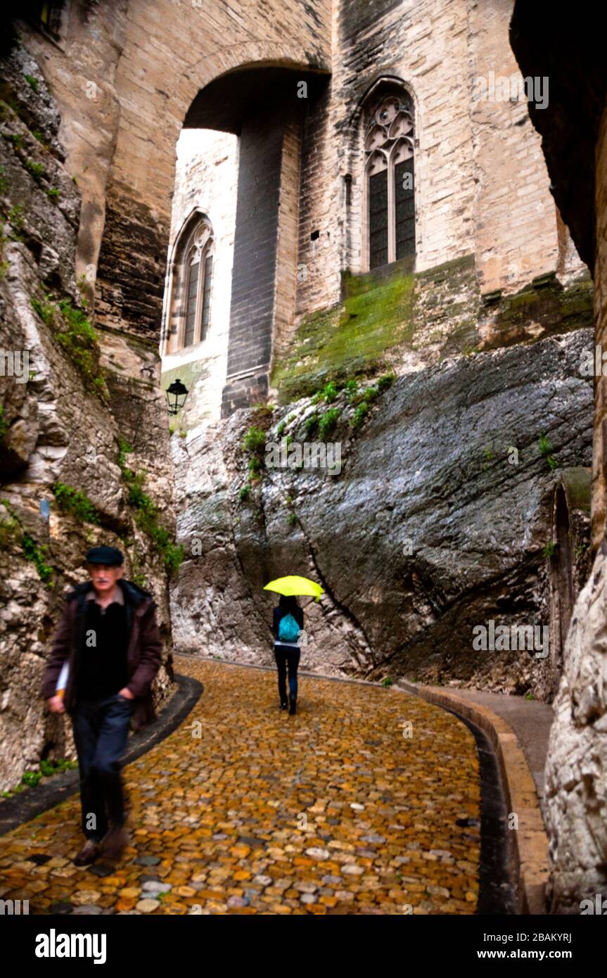 Strade acciottolate dell'arco di Avignone, affioramenti rocciosi e una finestra gotica. Foto Stock