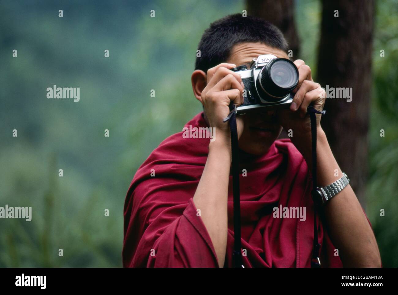 Un giovane monaco ha uno sguardo attraverso il mirino di una macchina fotografica a Cherri - Chagri Chedra, Bhutan. (17-09-89) BX04 Foto Stock