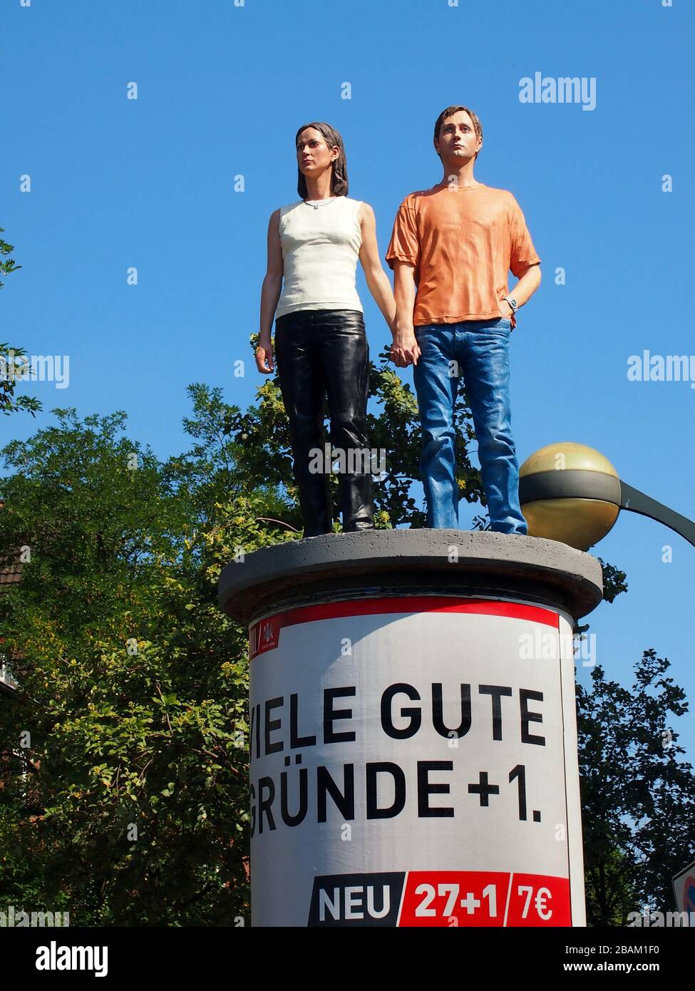 "Sviene sulle colonne": Opera di Christoph Pöggeler, raffigurante una scultura realistica di una coppia che si erge su un pilastro pubblicitario a Düsseldorf. Foto Stock