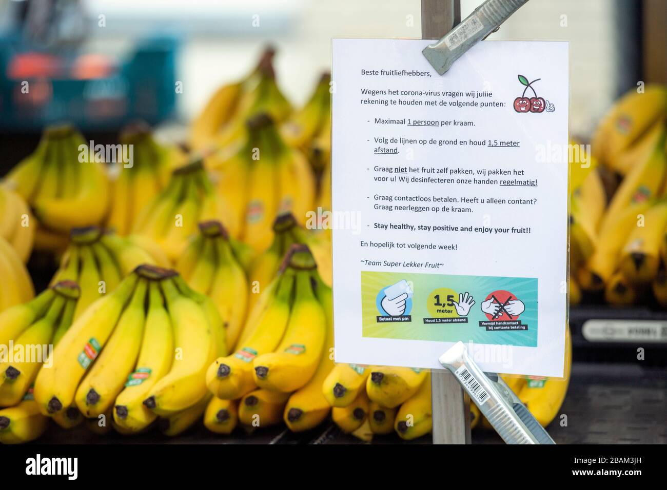 Il segno del coronavirus spiega le norme in materia di igiene e di distanziamento sociale in una bancarella di frutta in un mercato all'aperto a Veenendaal, Paesi Bassi Foto Stock