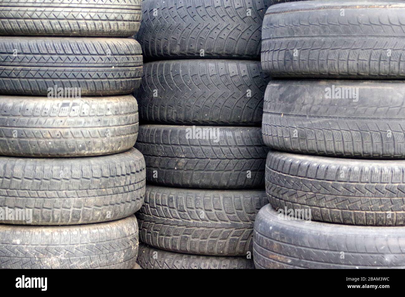 Pneumatici usati per auto, impilati l'uno sull'altro. Sostituzione stagionale degli pneumatici. Foto Stock