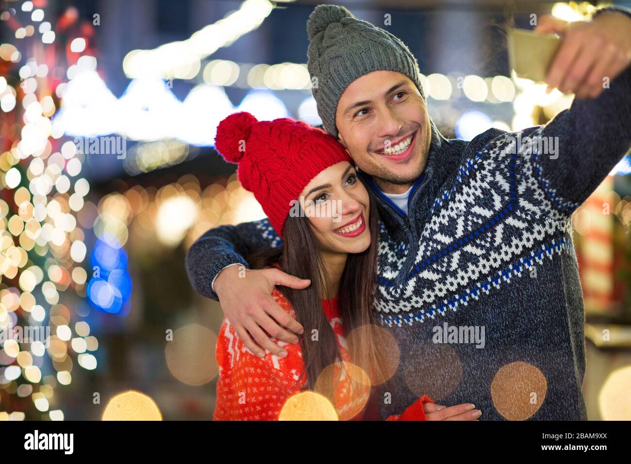 Giovane coppia che ha divertimento all'aperto a Natale Foto Stock