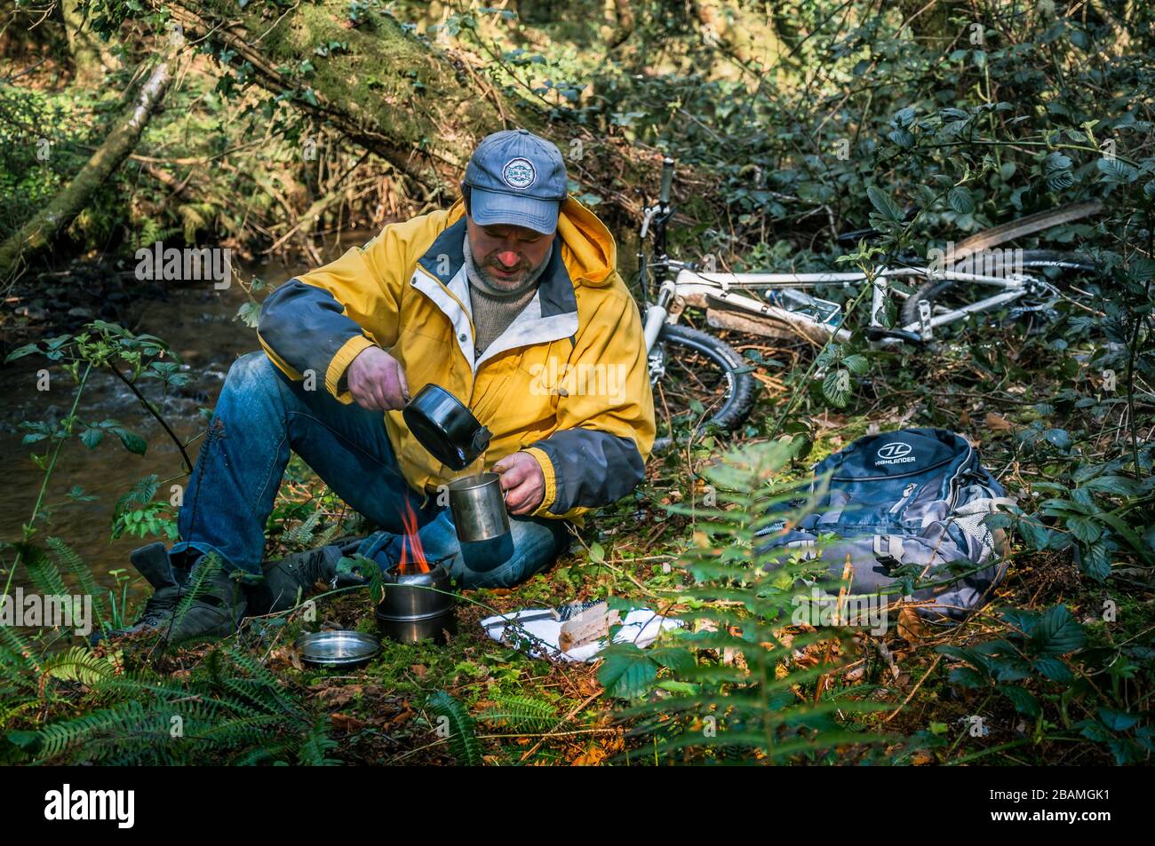 Preparare tè in bicicletta Irlanda. Ciclista facendo la sua colazione e praticando distancing sociale durante la mattina a boschi locali poco prima del blocco totale Foto Stock