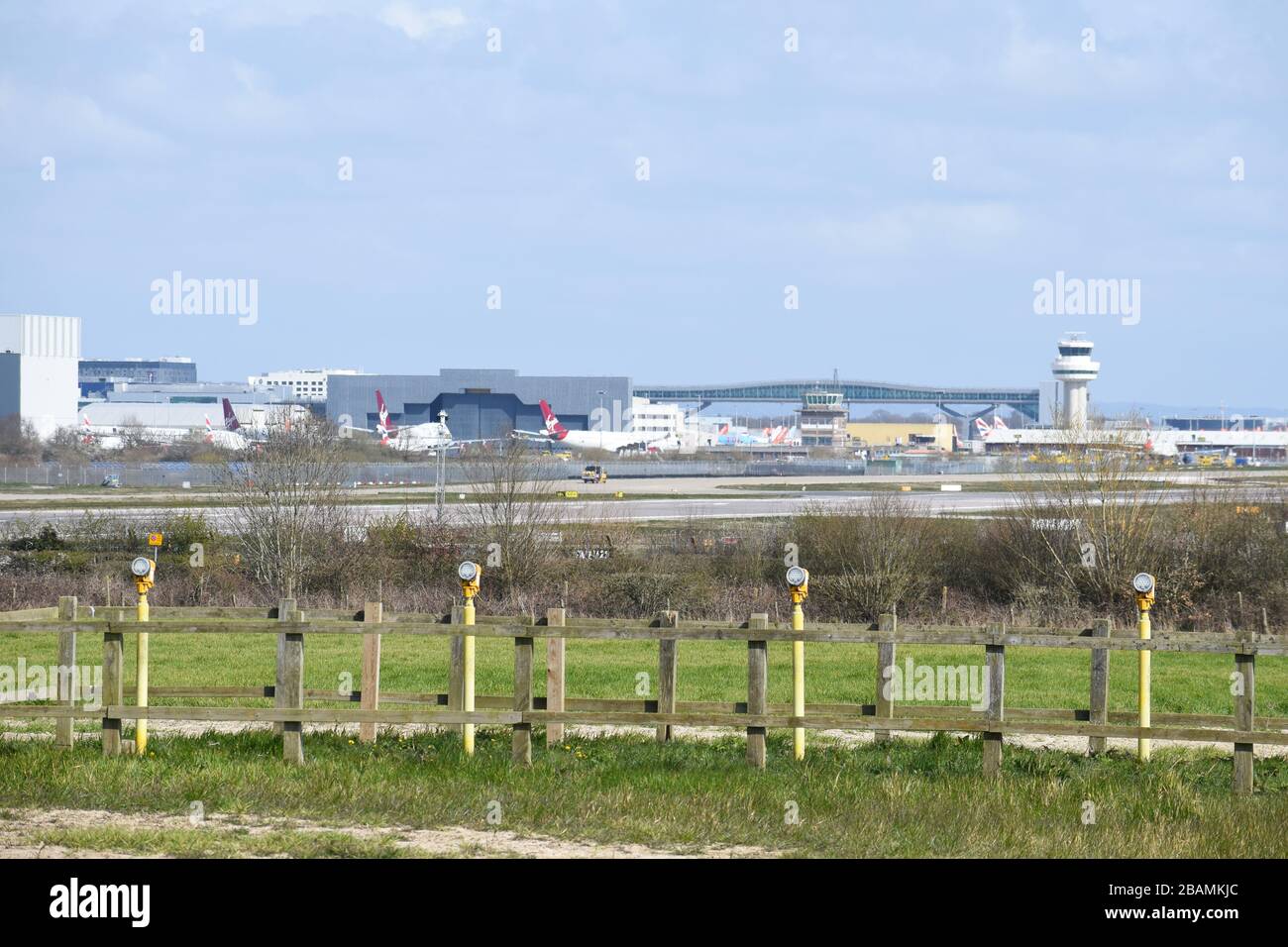 Vista attraverso le luci di atterraggio della pista per la torre di controllo del traffico aereo di Gatwick con Virgin Atlantic e British Airways terra aerei a causa di Covid-19. Foto Stock