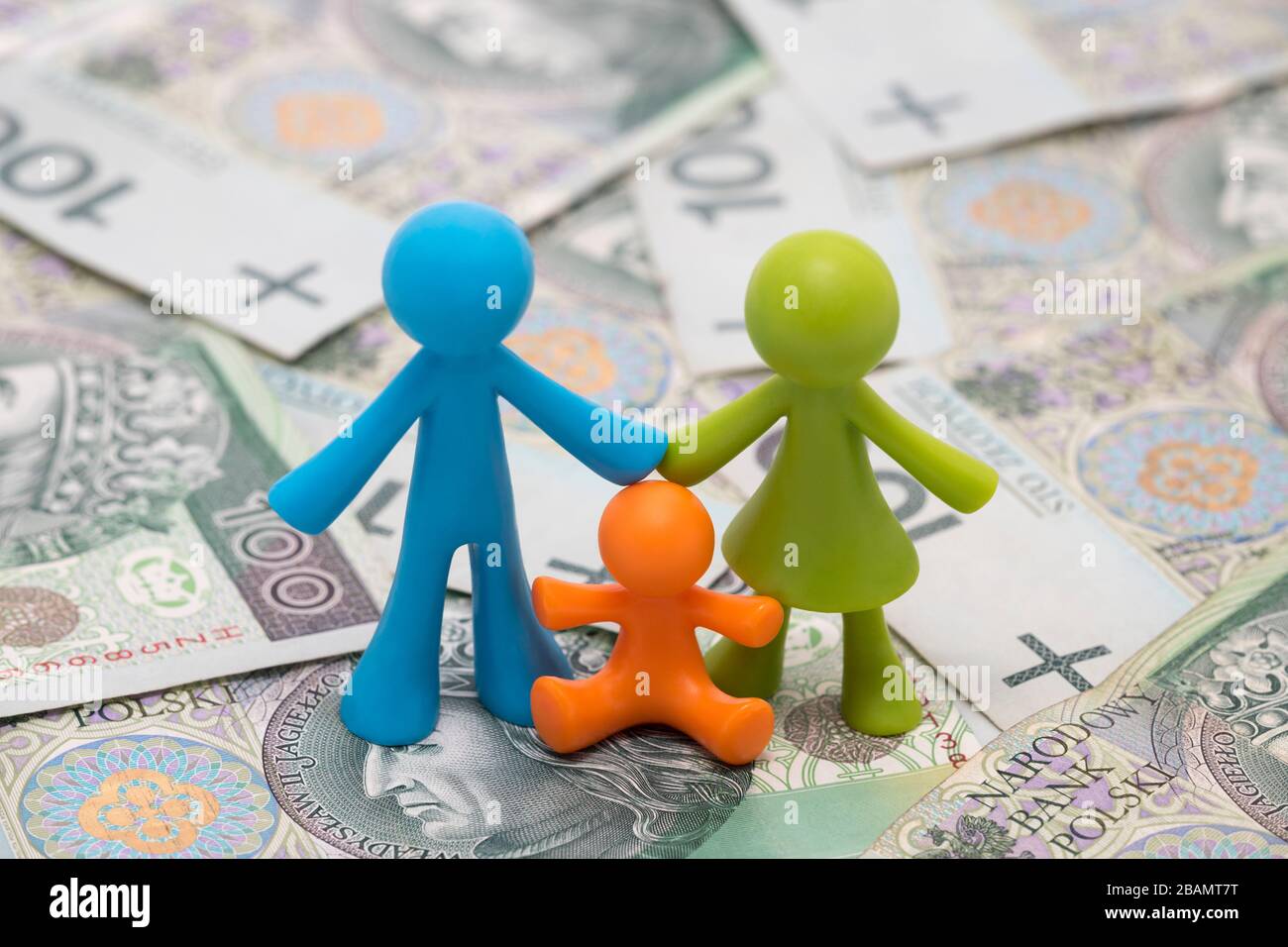 Figurine famiglia colorate su denaro polacco. Aiuto finanziario per le famiglie in Polonia o concetto di spese familiari Foto Stock