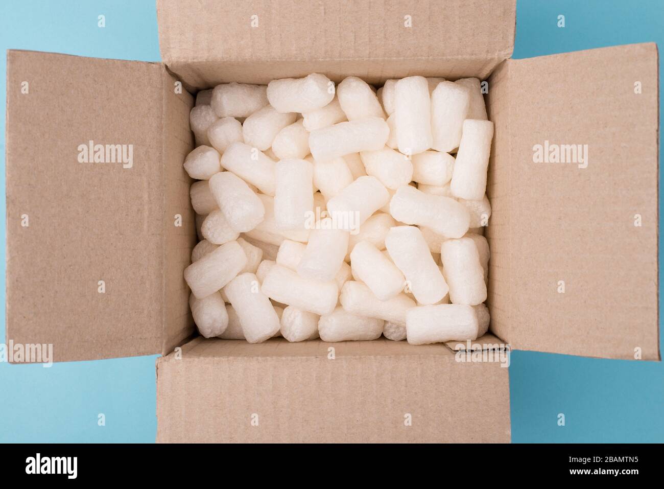 Foto della riempitrice in scatola di cartone su sfondo blu Foto Stock