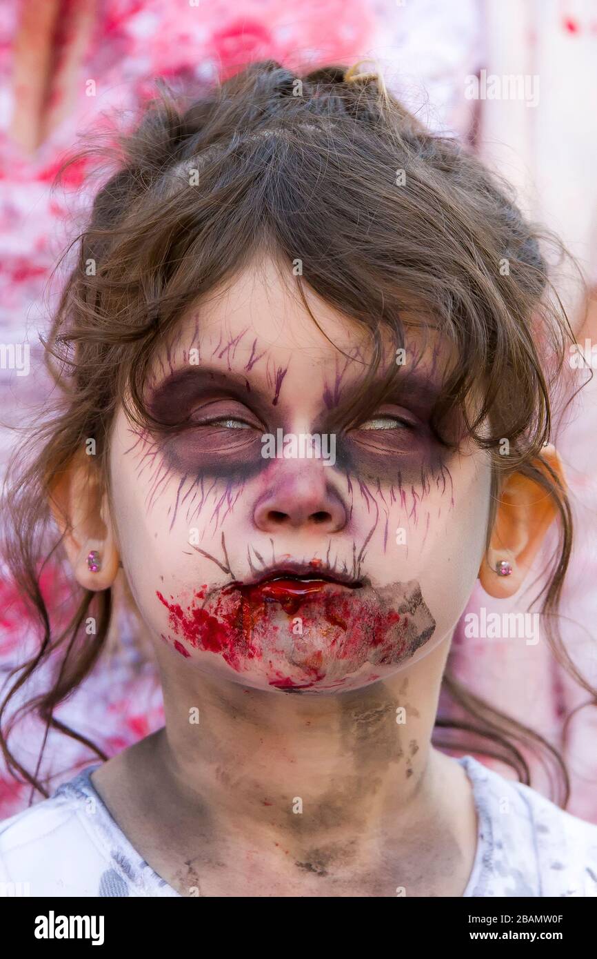 Saint John, New Brunswick, Canada - 21 ottobre 2017: Passeggiata zombie. Uno zombie femmina bambino mostra i bianchi dei suoi occhi. Foto Stock