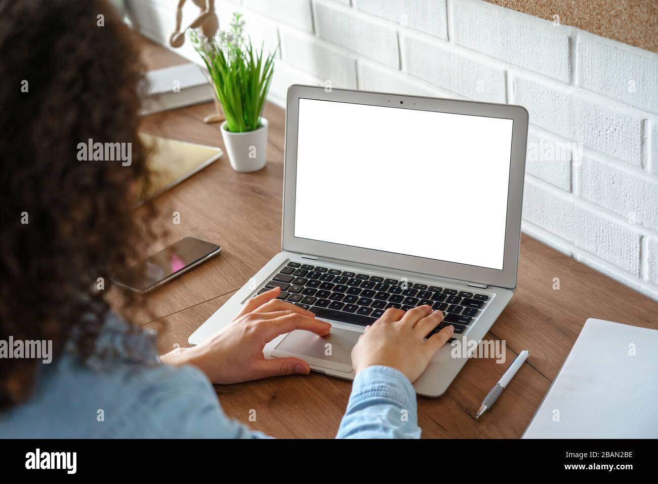 Ragazza africana che usa il laptop mock up schermo per il lavoro o lo studio. Foto Stock