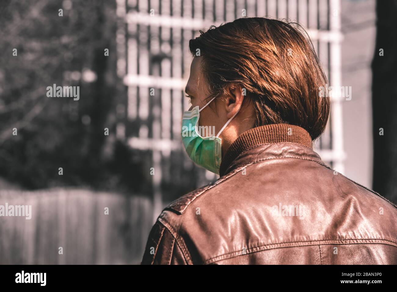 Corona - immagine concettuale di Covid-19 - vista posteriore di un uomo che indossa una maschera facciale Foto Stock
